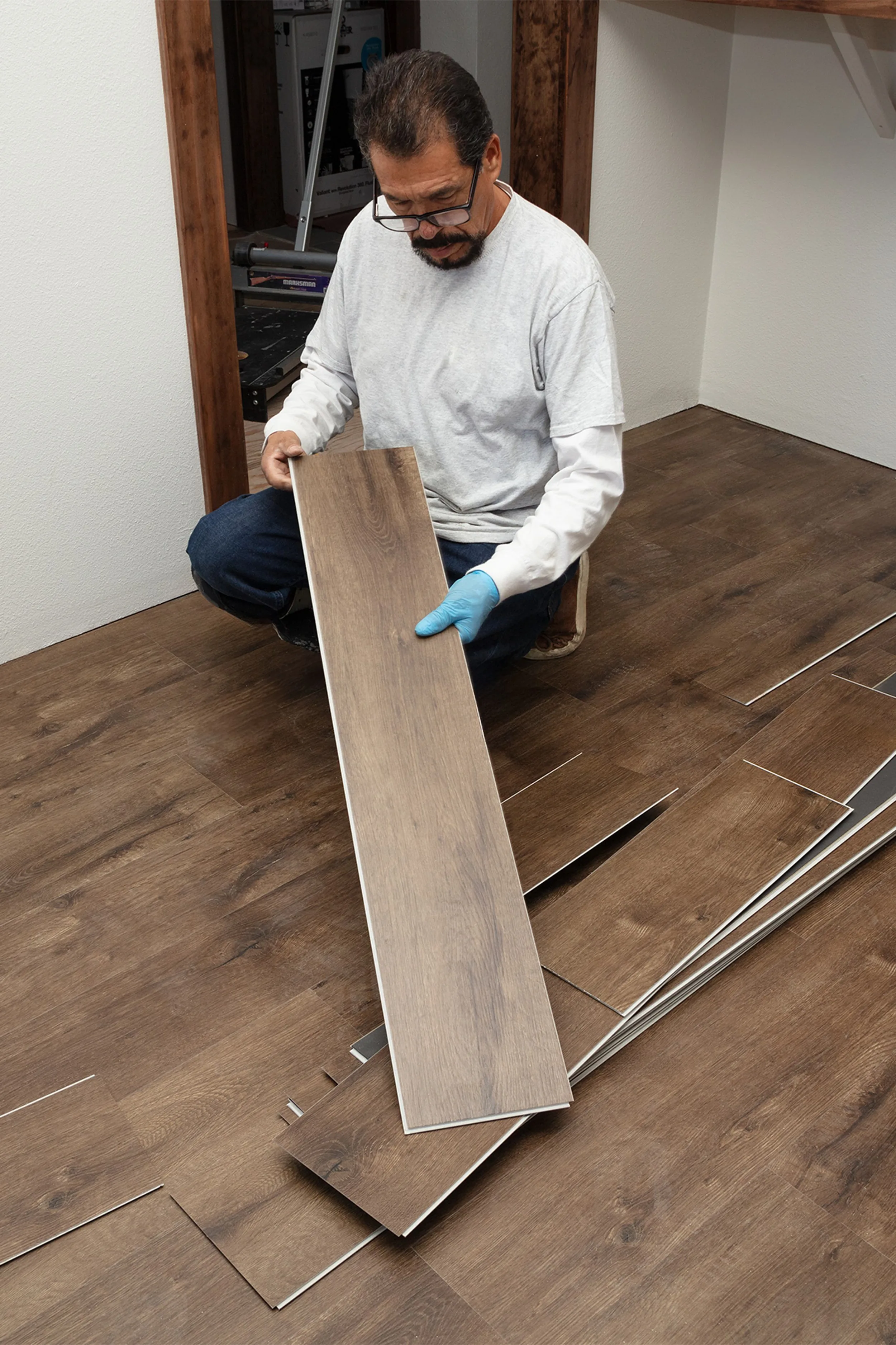 Installer laying vinyl plank flooring